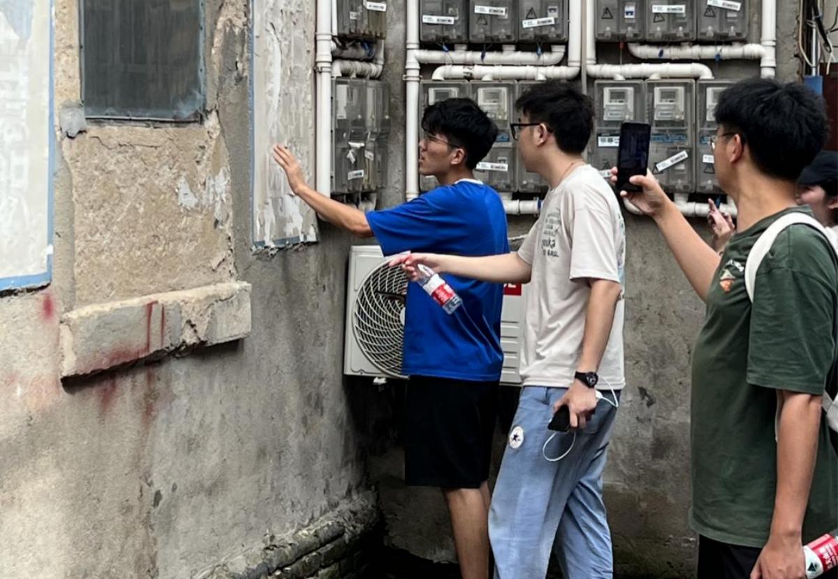 团队成员正在考察陈老巷墙体脱落问题（马克思主义学院 供图）(1)